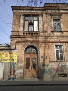 第比利斯Apartment Milena Tbilisi Onebedroom的街道上一座带木门的古老建筑