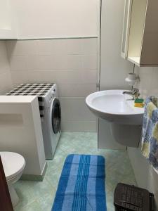 丽都玛里尼SPELU - Appartamento con terrazza fronte mare的一间带洗衣机和水槽的浴室