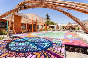 RivadaviaHostal Cosmo Elqui的一座拥有色彩缤纷的马赛克地板和拱门的游泳池