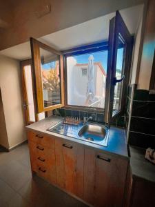 罗希姆诺Smyrni Rethymno Suites的一个带水槽和大窗户的厨房