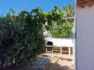 迈阿密普拉特亚Chalet Menorca的一个带比萨饼烤箱和灌木的花园