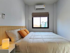 清莱Baan Trin(บ้านตฤณ)的一间卧室设有一张床和一个窗口