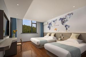 婺源Anlan Hotel Shangrao Wuyuan Cultural Plaza的墙上挂着世界地图的房间的两张床