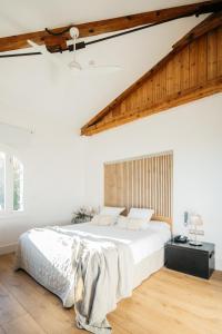 拉塞尔瓦德尔坎普Hotel Boutique Mas Passamaner的白色卧室设有一张大床和木地板