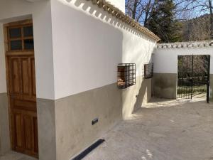 普埃夫拉德东法德里克Cortijo San Roque Alojamientos Rurales的白色的建筑,设有木门和庭院