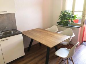 比勒费尔德Apartment in Innenstadt Bielefeld的厨房配有木桌和白色椅子