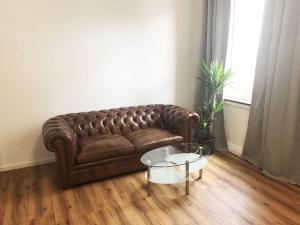 比勒费尔德Apartment in Innenstadt Bielefeld的客厅里一张棕色的皮沙发,配有桌子