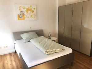 比勒费尔德Apartment in Innenstadt Bielefeld的一间卧室配有一张带白色床单的床和橱柜。