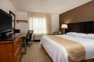 韦恩堡Travelodge by Wyndham Fort Wayne North的配有一张床和一台平面电视的酒店客房