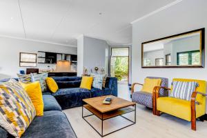 巴利托Baluwatu 10, Zimbali Estate的客厅配有蓝色的沙发和黄色的椅子