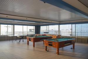 阿德里安诺斯坎波斯Adele Resort的大型客房设有2张台球桌和窗户。