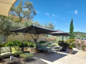 马洛塞讷Le Clos Saint Michel Resort & Spa的一个带桌椅和遮阳伞的庭院