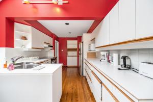 温哥华Tranquil Haven near Attractions 2BD Upper Floor or 2BD Basement Floor的厨房设有红色的墙壁和白色的橱柜