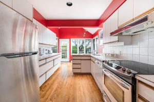 温哥华Tranquil Haven near Attractions 2BD Upper Floor or 2BD Basement Floor的一间设有白色橱柜和红色天花板的大厨房