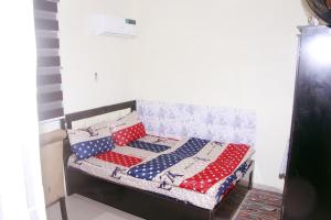 拉各斯Smilley's Place Ms-Tammy的一张带红色白色和蓝色枕头的床
