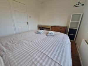 谢菲尔德Suite 1: Cosy Room in a Prime Location的一间卧室配有一张床,上面有两条毛巾