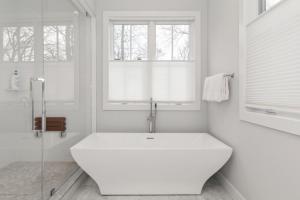 萨格港Villa Kimaal - Luxury with pool的白色的浴室设有大浴缸和窗户。