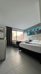 麦德林Hotel Gran Conquistador 33的大房间设有两张床和大窗户