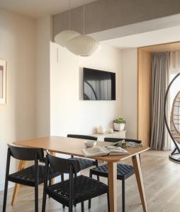 毕尔巴鄂Apartamentos Líbere Bilbao Museo的一间带木桌和椅子的用餐室