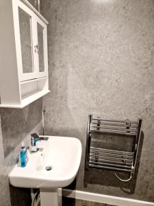 利斯卡德Wheal Tor Hotel & Glamping的浴室设有白色水槽和镜子