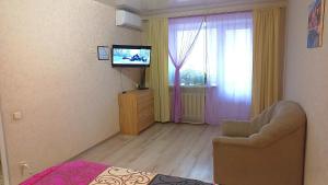 敖德萨Apartment - Generala Petrova Street的一间卧室配有电视、椅子和窗户