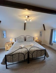 特鲁罗Maple & Beech Barns的一间卧室配有一张带2个床头柜的大床