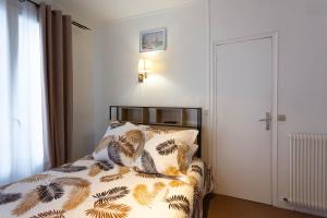 巴黎理想酒店的一间卧室配有一张带花卉棉被的床