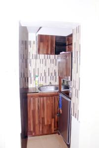 拉各斯Smilley's Place Szilvie的厨房配有木制橱柜和不锈钢冰箱。