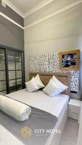 TürkistanCity Hotel Turkistan的卧室配有带白色枕头的大床