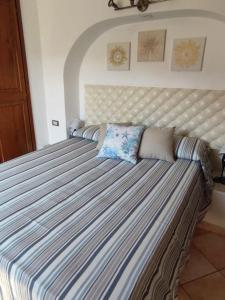 圣托斯特凡诺港La Casetta的卧室内的一张大床,带条纹床垫