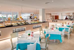 卡拉博纳Grupotel Mallorca Mar的一间设有蓝色桌椅的餐厅和一间厨房