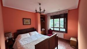 Os PearesCasa Alpargateiro的一间卧室拥有橙色的墙壁、一张床和窗户