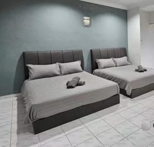 淡文Tambun Sunway Homestay的一间卧室配有两张带毛巾的床