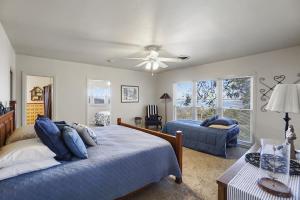 WhitneyOn Lake Retreats Family Gatherings Game Room Pets的一间卧室配有一张床、一张沙发和吊扇。