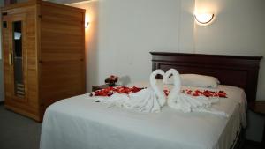 科塔卡奇HOSTERIA RANCHO SANTA FE的两天鹅在玫瑰床上的白色毛巾
