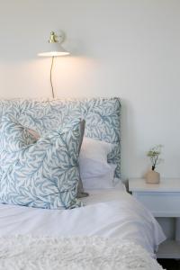 浦耳Poole Park House的一张带蓝色和白色枕头的床和一盏灯