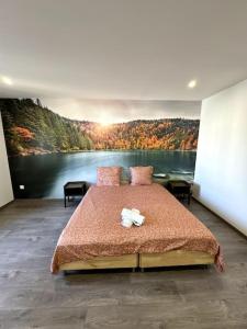 埃皮纳勒Le Paris-Vosges的卧室配有一张大床,墙上挂有绘画作品