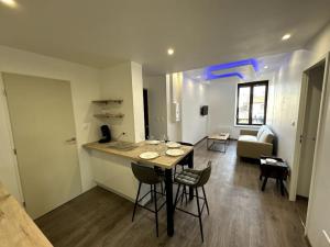 埃皮纳勒Le Paris-Vosges的厨房以及带桌椅的起居室。