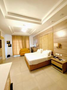 乌约1401 Luxury Apartment的一间卧室配有一张大床和一张黄色椅子