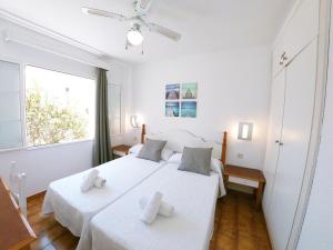 阿雷纳尔登卡斯特尔Apartamento 107 Castell Sol CB的一间卧室设有两张带白色床单的床和窗户。