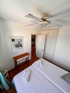 阿雷纳尔登卡斯特尔Apartamento 107 Castell Sol CB的一间卧室配有一张床和吊扇
