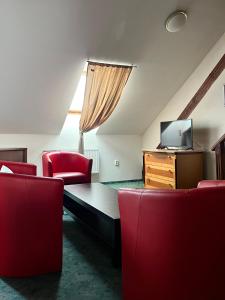 布拉格GEO酒店的客厅配有红色椅子和平面电视