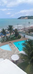 纳塔尔Beira-Mar flat 310 Ponta Negra Beach的海滩旁两个游泳池的顶部景色