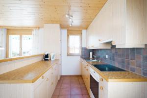 艾姆敦Apartment Brugg的厨房配有白色橱柜和木制柜台。