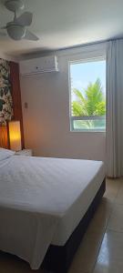 纳塔尔Beira-Mar flat 310 Ponta Negra Beach的一间卧室设有一张床,窗户拥有棕榈树