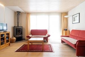 艾姆敦Apartment Bischofberger D20的客厅配有红色的沙发和桌子