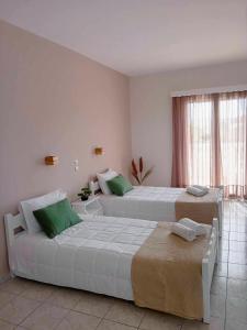 拉加纳斯Lunzi Verde的配有绿色枕头的酒店客房内的两张床