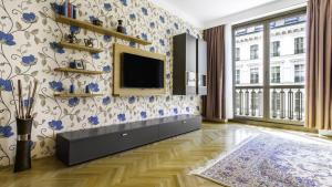 维也纳阿比舒梅斯服务式公寓 - 歌剧院的客厅的墙上挂有蓝色花卉,配有电视