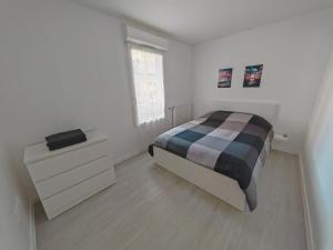 圣吉欧梅斯Paris 15 min Appartement tout confort 6 couchages的一间卧室配有一张床、一个梳妆台和一扇窗户。