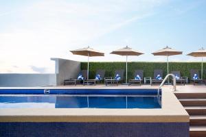 阿瓜斯卡连特斯Fairfield Inn & Suites by Marriott Aguascalientes的一个带椅子和遮阳伞的游泳池